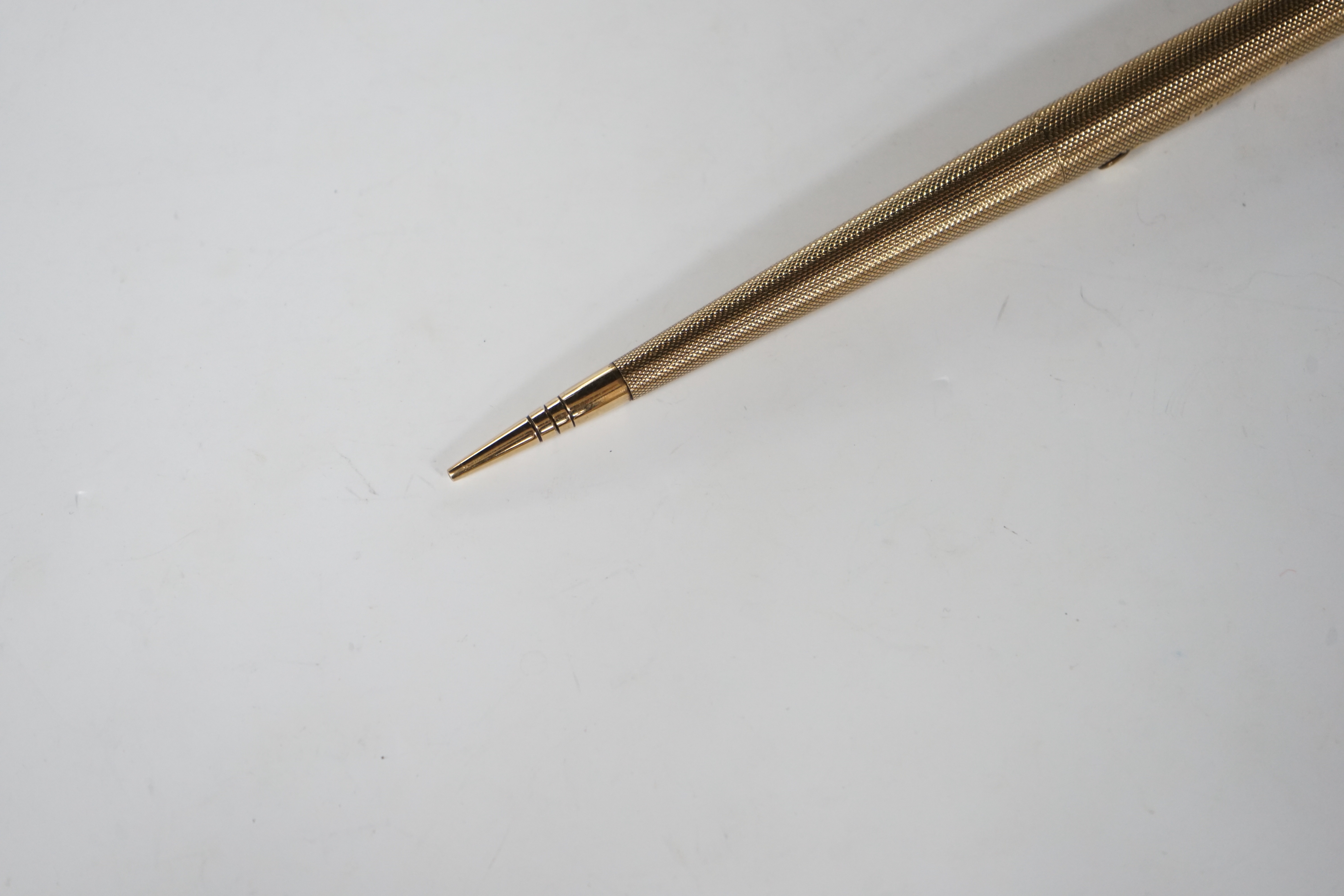 A George V engine turned 9ct. gold combination fountain pen and pencil, with holder (once attached to a stand), maker F.D.W. London, 1935, 20.4cm.
